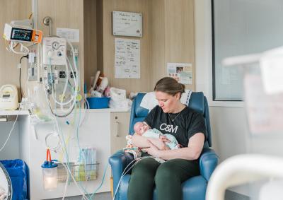 A mum holding her newborn in hospital.